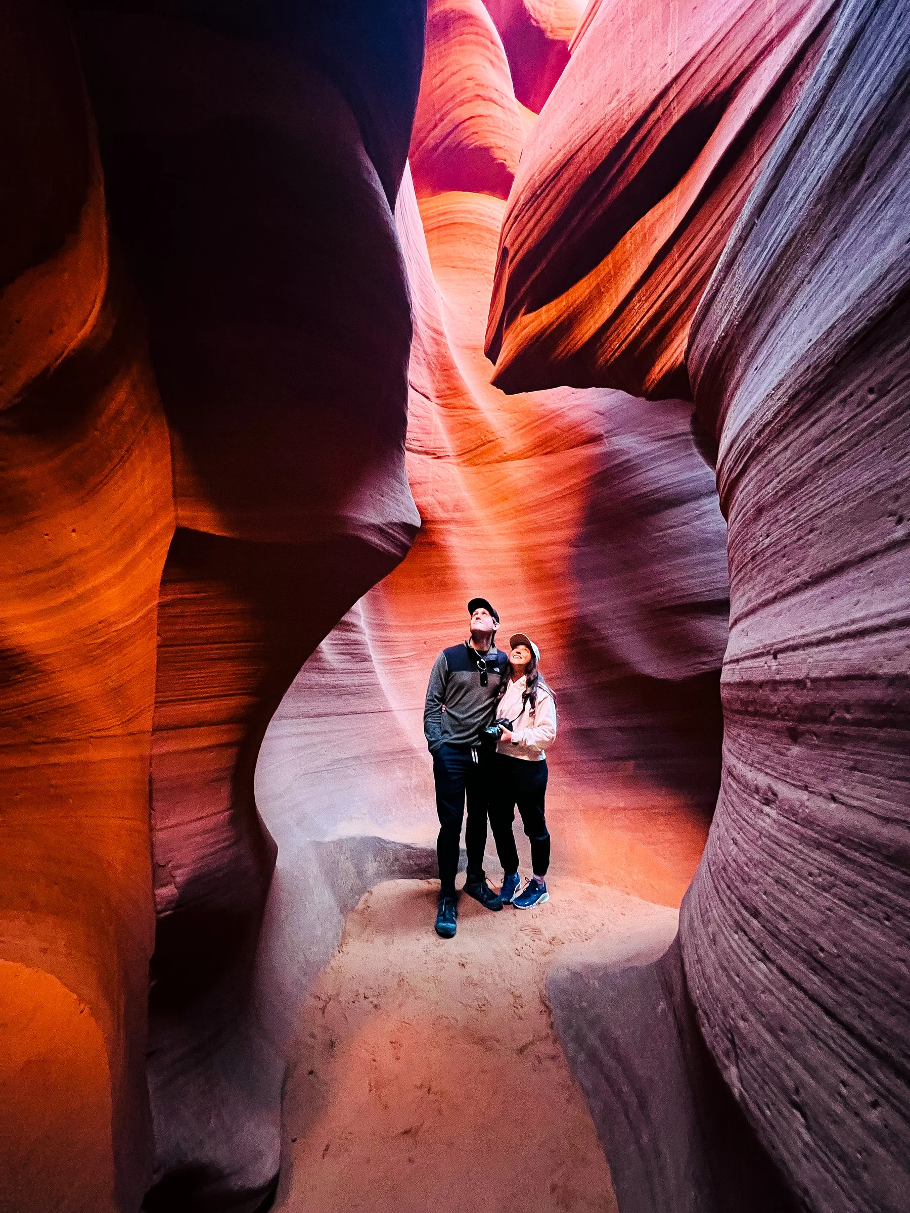 Brendon and Kaylee standing together in a glowing orange slot canyon.